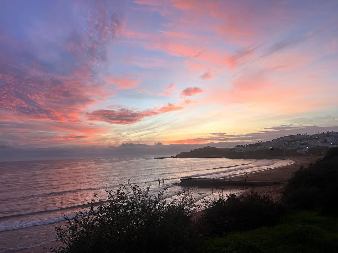 Pôr do sol cor-de-rosa sobre o mar e a praia de Albufeira, visto do alto
